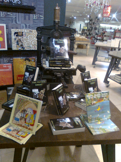 Photo of books arranged on and around an old printing press